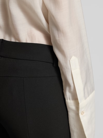 Frauenmodel trägt Flared Fit Stoffhose mit Viskose-Anteil Modell 'Farah' von Cambio, schwarz, glatte Textur, Detailaufnahme Hüfte.