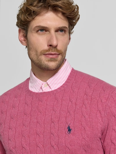 Männermodel trägt Regular Fit Pullover aus Woll-Kaschmir-Mix von Polo Ralph Lauren in Pink mit Zopfmuster-Textur, Nahaufnahme Oberkörper, Herren Pullover von Polo Ralph Lauren
