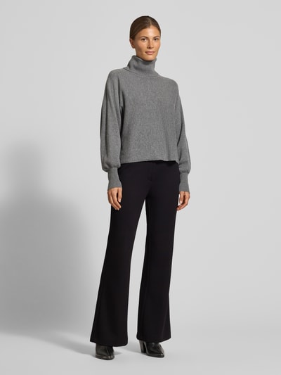 Frauenmodel trägt Flared Cut Hose mit elastischem Bund von Christian Berg Woman, schwarz, Material-Mix mit Viskose-Anteil, Ganzkörperansicht von vorne
