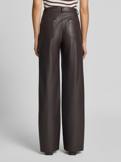 Frauenmodel trägt Straight Fit Hose mit Eingrifftaschen von Marc Cain in Leder-Optik, dunkles Braun, sichtbare Gesäßtaschen, Ganzkörperansicht Rückansicht.