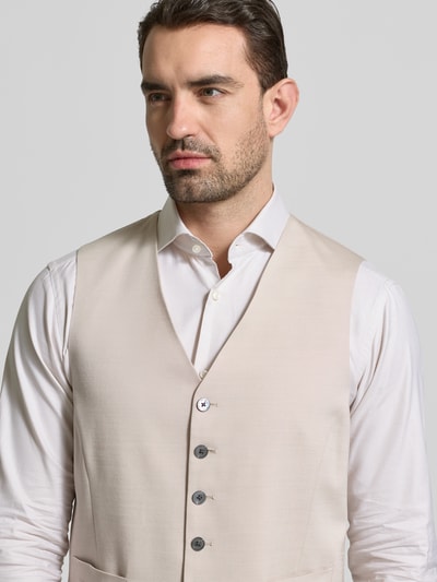 Mannelijk model draagt Regular Fit Weste aus Viskose-Mix mit V-Ausschnitt van JOOP! Collection in lichtbeige, gladde structuur, detailopname bovenlichaam.