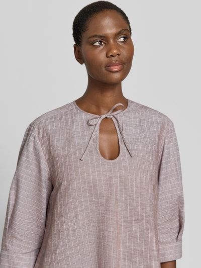 Frauenmodel trägt Midikleid aus Leinen-Baumwoll-Mix mit 3/4-Arm von MM by Max Mara, schimmerndes Violett mit feinen weißen Streifen, Nahaufnahme Oberkörper. Modell 'MEMO' mit Schlüsselloch-Ausschnitt, Wide-Fit, Rückenlänge 126 cm, Brustweite 50 cm, Ärmellänge 40 cm.