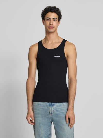 Männermodel trägt schwarzes Tanktop in Ripp-Optik mit Logo von REVIEW aus reiner Baumwolle, Slim-Fit, Rundhalsausschnitt, Ganzkörperansicht von vorne.