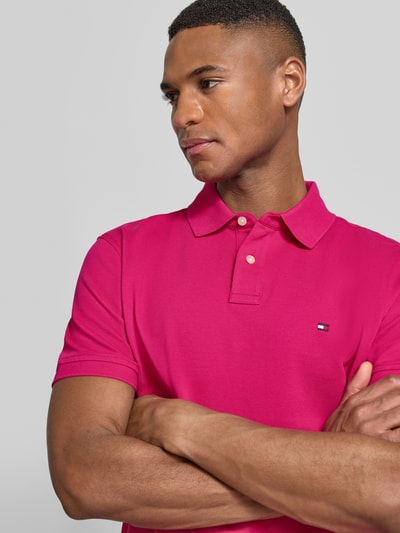 Mannermodel draagt Regular Fit Poloshirt aus Baumwoll-Mix van Tommy Hilfiger in effen kleuren, gestikt logo, piqué, nahaufnahme bovenlichaam.