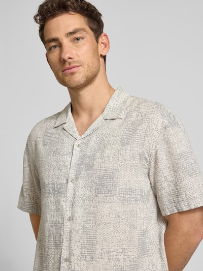 Männermodel trägt Relaxed Fit Freizeithemd aus Leinen-Lyocell-Mix von CK Calvin Klein mit grafischem Allover-Muster, Nahaufnahme Oberkörper.