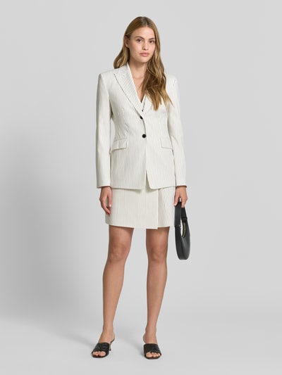 Frauenmodel trägt Leicht ausgestellter Mini-Rock in Wickeloptik Modell 'RIBERI' von HUGO mit gestreiftem Allover-Muster in Twill, Ganzkörperansicht von vorne.