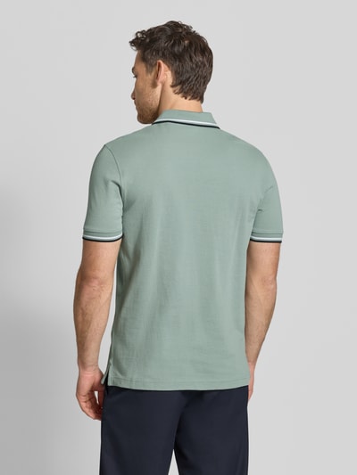 Männermodel trägt Regular Fit Poloshirt mit Kontraststreifen von Christian Berg Men aus Reiner Baumwolle, Rückenlänge 71 cm, Ganzkörperansicht Rückansicht.