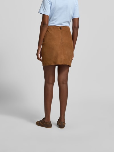 Frauenmodel trägt Minirock aus echtem Ziegenvelours von ROTATE in Suede-Optik mit Strukturmuster, Slim-Fit, Nahtreißverschluss, Ganzkörperansicht Rückansicht. Gesamtlänge 43 cm, Bundweite 35 cm bei Größe 36.