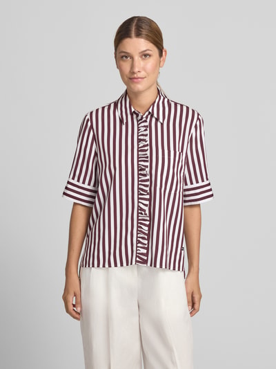 Frauenmodel trägt Regular Fit Hemdbluse aus Viskose-Mix Modell 'VICA FRIL' von Brax in Weiß mit bordeauxroten Streifen, Ganzkörperansicht von vorne. Damen Kurzarmbluse.