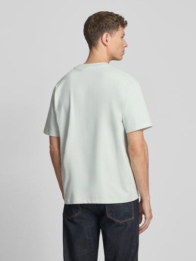 Męski model nosi Oversized T-Shirt mit Rundhalsausschnitt von Lindbergh z bawełny, detal z logo, długość tyłu 70 cm, Ganzkörperansicht Rückansicht.
