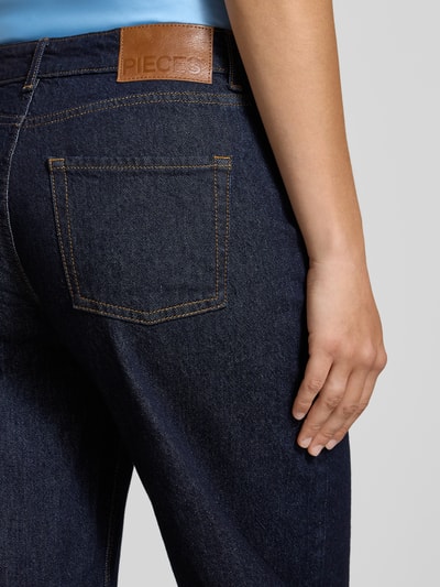 Frauenmodel trägt Barrel Jeans aus Baumwoll-Mix Modell 'GRACE' von PIECES in dunklem Blau, sichtbare Struktur, Nahaufnahme Rückansicht, Damen Barrel Jeans von PIECES.