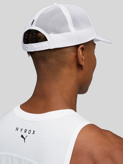 Männermodel trägt Basecap mit Label-Print von PUMA PERFORMANCE aus reiner Baumwolle, verstärkter Schirm, semitransparenter Einsatz, verstellbarer Verschluss, Ganzkörperansicht Rückansicht.