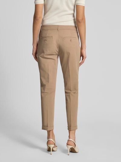 Frauenmodel trägt Chino aus Techno Cotton Superstretch Modell 'UTE' von Raffaello Rossi in Beige mit Bügelfalten, Gesäßtaschen, Verkürzt, Ganzkörperansicht Rückansicht. Elastischer-Material-Mix mit Baumwoll-Anteil, Straight Fit, Knopf- und Reißverschluss, fixierte Beinumschläge, Gürtelschlaufen, Bundweite bei Größe 36: 40 cm, Innenbeinlänge bei Größe 36: 68 cm.