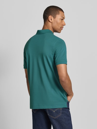 Männermodel trägt Regular Fit Poloshirt mit Stitching von Christian Berg Men in Türkis, reine Baumwolle, Rückenansicht, Ganzkörperansicht.