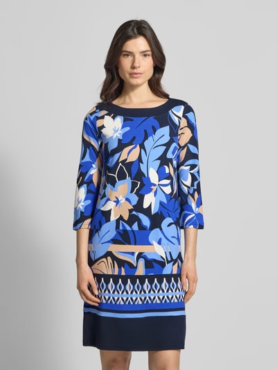 Vrouwenmodel draagt Knielanges Kleid aus Viskose-Mix im Allover-Look van Betty Barclay, blauwe tinten, rechte fit, ronde hals, 3/4-mouw, all-over look, ruglengte maat 36: 87 cm, borstwijdte 45 cm, mouwlengte 46 cm. Ganzkörperaanzicht van voren.