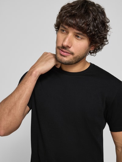 Männermodel trägt schwarzes T-Shirt mit Rundhalsausschnitt Modell 'DEN' von CINQUE aus Baumwolle, Regular Fit, Nahaufnahme Oberkörper