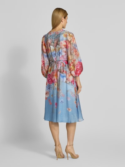 Frauenmodel trägt Cocktailkleid mit Bindegürtel von V by Vera Mont in Allover-Look, taillierter Schnitt, Midikleid, Rückenlänge 113 cm, Ganzkörperansicht Rückansicht.