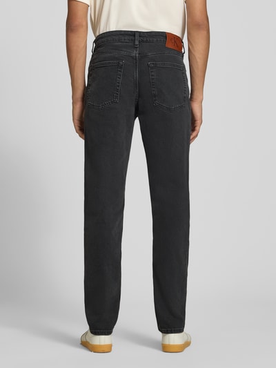 Mężczyzna nosi Slim Fit Jeans aus Baumwoll-Mix von Calvin Klein Jeans, ciemnoszare, proste nogawki, widoczne kieszenie, zdjęcie całej sylwetki z tyłu.