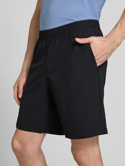 Männermodel trägt Regular Fit Sport-Shorts mit Label Print Modell 'TREVOL' von BOSS Green, schwarze 4-way Stretch-Shorts, Nahaufnahme Oberschenkel Vorderansicht