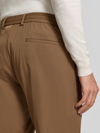 Männermodel trägt Hose mit elastischem Bund und Tunnelzug von bugatti, Materialmix mit stretch, krój regular fit, Nahaufnahme Rückansicht, Szerokość w rozmiarze 50: 44 cm, długość nogawki od wewnątrz w rozmiarze 50: 83 cm
