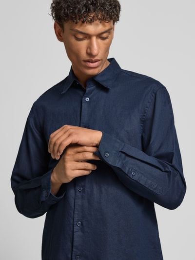 Männermodel trägt Regular Fit Freizeithemd aus Leinen-Baumwoll-Mix Modell 'CLAY LINENBLEND' von SELECTED HOMME in Dunkelblau, Melange-Optik, Kentkragen, durchgehende Knopfleiste, Flammgarn-Textur, Nahaufnahme Oberkörper.
