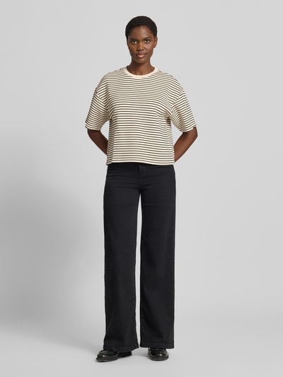 Kobieta prezentuje damski t-shirt 'Oversized Fit T-Shirt aus Viskose-Mit' von MSCH Copenhagen, mieszanka wiskozy, krój oversized fit, okrągły dekolt, rękaw o dł. 1/2, długość tyłu w rozmiarze XS/S: 54 cm, widok całej sylwetki z przodu.