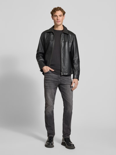 Männermodel trägt Tapered Fit Jeans aus Baumwoll-Mix Modell 'Redford' von Wrangler in Grau, dezente Waschung, Ganzkörperansicht von vorne.
