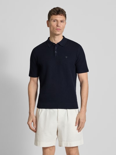 Männermodel trägt Regular Fit Poloshirt in Strick-Optik von Fynch-Hatton, dunkelblau, Baumwoll-Mix, Logo-Stitching, Polokragen, Ganzkörperansicht von vorne. Rückenlänge bei Größe M: 67 cm.