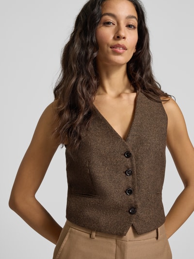 Frauenmodel trägt Regular Fit Weste mit V-Ausschnitt Modell 'PIPER' von Mango in Braun, Knopfleiste, Paspeltaschen, Nahaufnahme Oberkörper