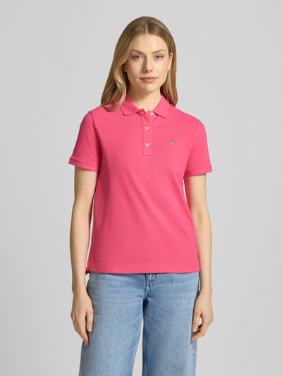 Frauenmodel trägt Poloshirt mit Logo-Stitching und Polokragen von Gant in Pink aus Reine Baumwolle, Regular-Fit, kurze Knopfleiste, Ganzkörperansicht von vorne. Rückenlänge bei Größe S: 57 cm.