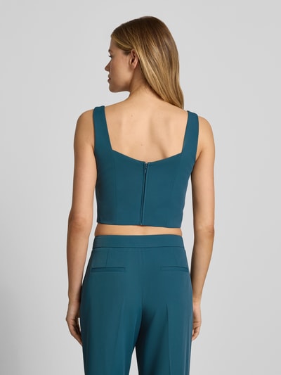 Frauenmodel trägt Cropped Top mit Karree-Ausschnitt und rückseitigem Reißverschluss von Jake*s Cocktail in Blau, Material-Mix mit Stretch-Anteil, körpernaher Schnitt, rückseitiger Haken- und Reißverschluss, Rückenlänge bei Größe 36: 20 cm, Ganzkörperansicht Rückansicht.