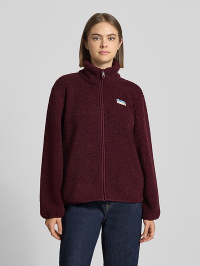 Vrouwenmodel draagt bordeauxrode Regular Fit Fleecejacke mit Reißverschluss Modell 'EVA' van ONLY, zachte structuur, Ganzkörperansicht van voren, dames fleecejack.