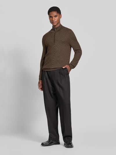 Männermodel trägt Regular Fit Strickpullover aus Schurwolle von Emporio Armani in Braun mit Troyer-Kragen, Ganzkörperansicht von vorne.