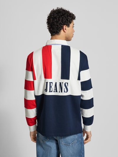 Männermodel trägt Relaxed Fit Poloshirt aus reiner Baumwolle von Tommy Jeans, Optik: unifarben, mehrfarbig, Ganzkörperansicht Rückansicht.