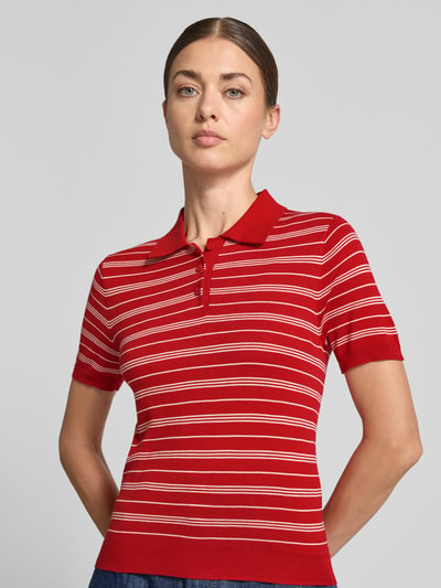 Frauenmodel trägt Slim Fit Strick-Poloshirt aus Viskose-Mix Modell 'POLVITO' von MANGO, rot mit weißen Streifen, Nahaufnahme Oberkörper. Damen Strick-Poloshirt aus Viskose-Baumwoll-Mix, Polokragen, gerippte Abschlüsse, Rückenlänge 53 cm, Ärmellänge 21 cm.