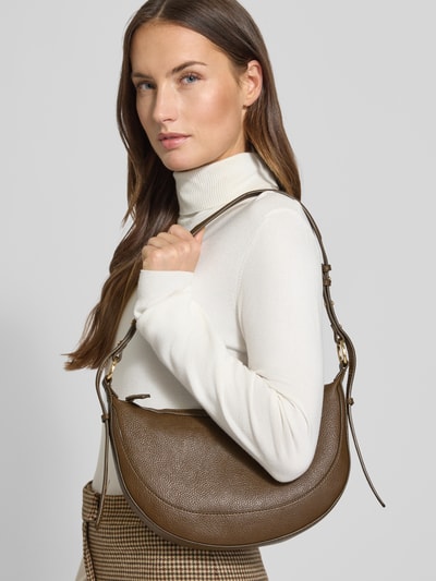 Frauenmodel trägt Shoulder Bag mit Reißverschluss von Mango in brauner Leder-Optik mit Ziernähten, Hauptfach, verstellbarem Schulterriemen, Nahaufnahme Oberkörper.