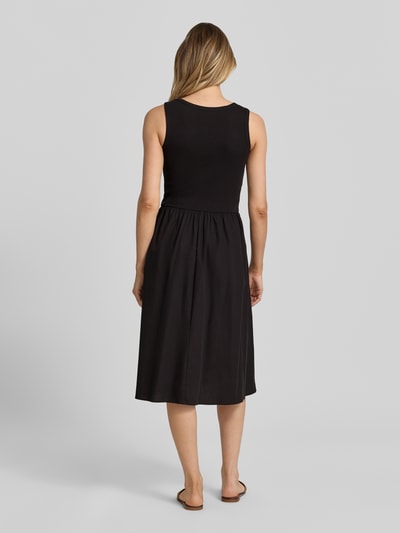 Frauenmodel trägt Knielanges Kleid im 2-in-1-Look von Soyaconcept in Schwarz, Reine Baumwolle, A-Linie, Rundhalsausschnitt, Knielänge, Rückenansicht Ganzkörperansicht. Rückenlänge Größe S: 100 cm, Brustweite Größe S: 33 cm.