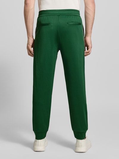 Männermodel trägt grüne Sweatpants mit elastischem Bund von ARMANI EXCHANGE, lockerer Schnitt, Baumwoll-Mix, Rückansicht Ganzkörperansicht.