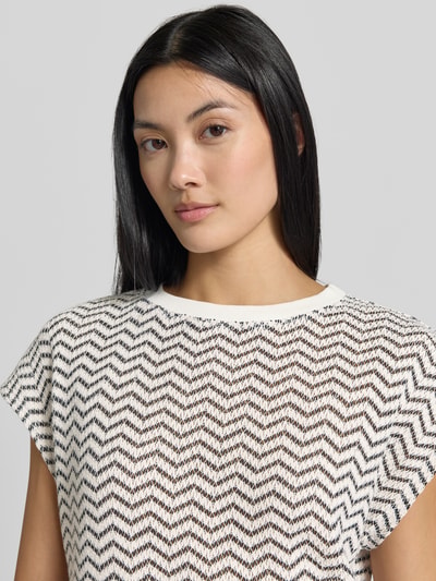 Kobiece modelka nosi Regular Fit T-Shirt in Strick-Optik od COMMA, mieszanka bawełny, półprzezroczysty materiał, dekolt w łódkę, z krótkim rękawem, imitacja dzianiny, widoczne biało-czarne zygzakowate wzory, Nahaufnahme górnej części ciała.