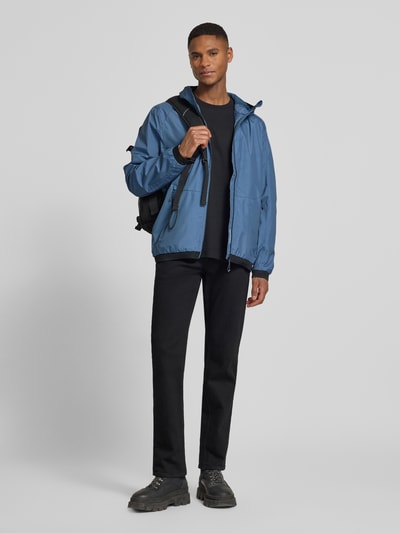 Mannenmodel draagt Jacke met capuchon Modell 'KOS' van Killtec in blauw met rechte fit, rits, label-patch, zijritszakken, elastische mouwuiteinden, volledig lichaam vooraanzicht.