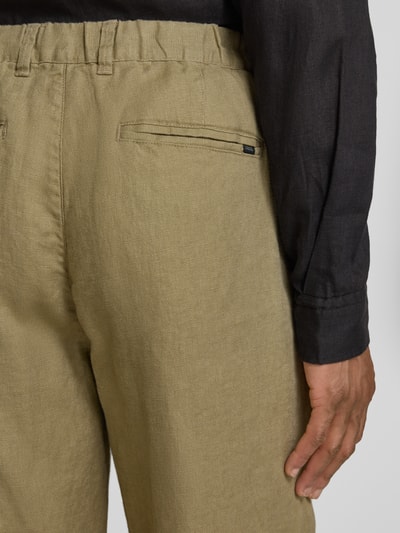 Männermodel trägt Leinenhose mit Eingrifftaschen Modell 'Pandrup' von Casual Friday, reines Leinen, krój regular fit, Szerokość w rozmiarze 32/32: 42 cm, długość nogawki od wewnątrz w rozmiarze 32/32: 83 cm, kolor oliwkowy, gładka faktura, detailaufnahme Rückansicht.