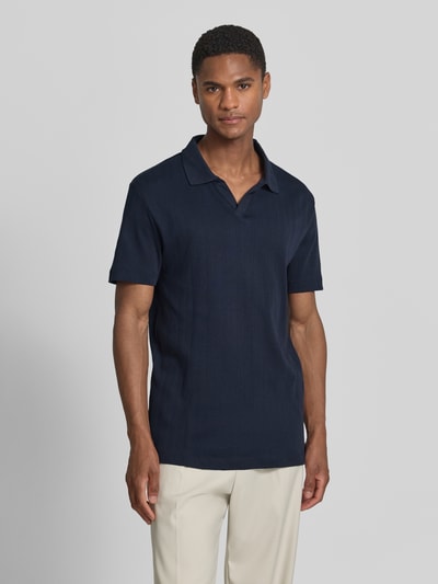 Männermodel trägt Regular Fit Poloshirt in Jaquard-Strick von Lindbergh in Dunkelblau, Reine Baumwolle, Polokragen, V-Ausschnitt, Label-Detail, Rückenlänge bei Größe M 73 cm, Ganzkörperansicht von vorne.
