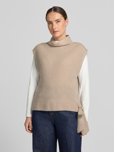 Kobiece model prezentuje Relaxed Fit Pullunder aus reinem Kaschmir mit Stehkragen od Christian Berg Woman, beżowy, Ozdobna kokarda przy dole, stójka, Bez rękawów, Długość tyłu w rozmiarze S: 52 cm, tekstura prążkowana, Ganzkörperansicht von vorne.