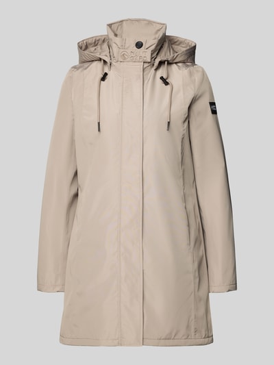 Frauenmodel trägt Regular Fit Mantel mit Logo-Applikation von NAUTGÅRD in Beige mit Stehkragen, Kapuze mit Tunnelzug, Eingrifftaschen, Ganzkörperansicht von vorne. Rückenlänge 88 cm, Schulterbreite 37 cm, Brustweite 48 cm, Ärmellänge 63 cm bei Größe S.
