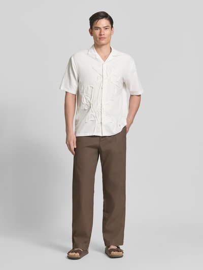 Männermodel trägt Leinenhose mit elastischem Bund und Eingrifftaschen von GAP in Braun, Loose Fit, Ganzkörperansicht von vorne.