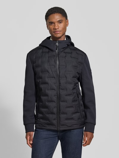 Männermodel trägt Regular Fit Steppjacke mit winddichter Funktion von Strellson in Schwarz, strukturierte Oberfläche, Ganzkörperansicht von vorne, Herren Steppjacke von Strellson.