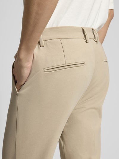 Männermodel trägt Regular Fit Stoffhose aus Baumwoll-Mix von Drykorn in Beige mit Gesäßtaschen, Detailaufnahme Rückenansicht