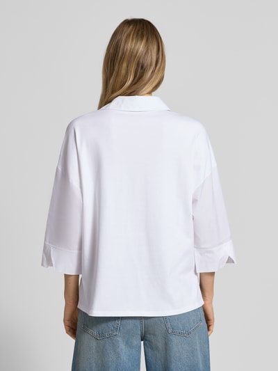 Frauenmodel trägt weißes Blusenshirt mit 3/4-Arm von Marc Cain aus reiner Baumwolle, lockerer Schnitt, Rückansicht, Ganzkörperansicht.