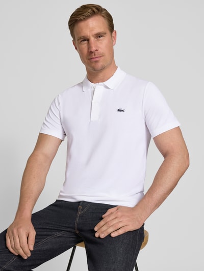 Männermodel trägt Regular Fit Poloshirt aus Baumwoll-Mix von Lacoste, Optik: Unifarben, Logo-Patch, Polokragen, Kurzarm, Nahaufnahme Oberkörper.