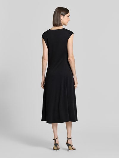 Männermodel trägt Regular Fit Midikleid mit Wasserfall-Ausschnitt Modell 'Vetusta' von MM by Max Mara, czarny, krój regular fit, micromodal, bez rękawów, długość tyłu w rozmiarze S: 120 cm, szerokość w rozmiarze S: 43 cm, widok całej sylwetki z tyłu.